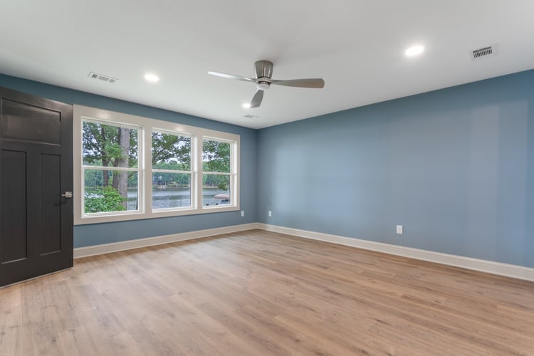 Room with wood flooring and light blue wall paint in custom home remodel by PAXISgroup