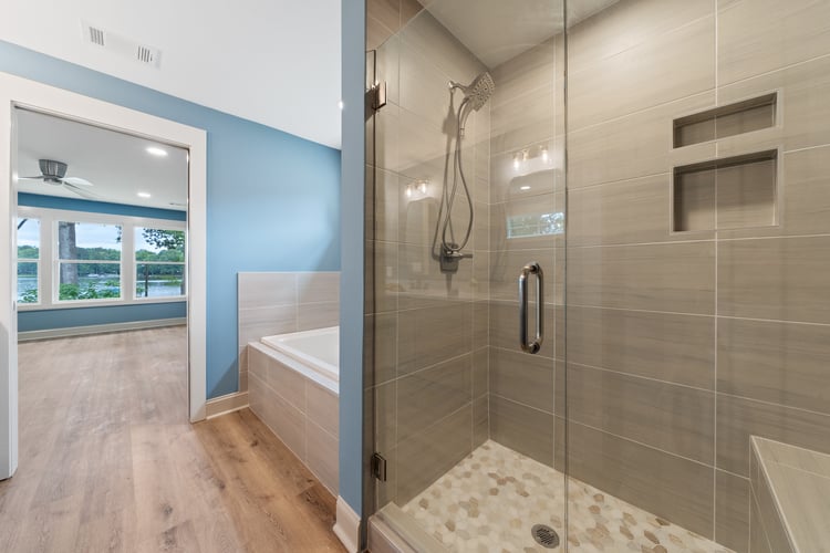 Walk in shower next to bathtub in custom home remodel by PAXISgroup