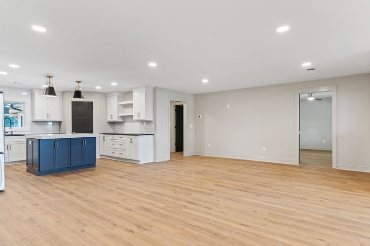 Wood flooring in open concept living space in custom home remodel by PAXISgroup