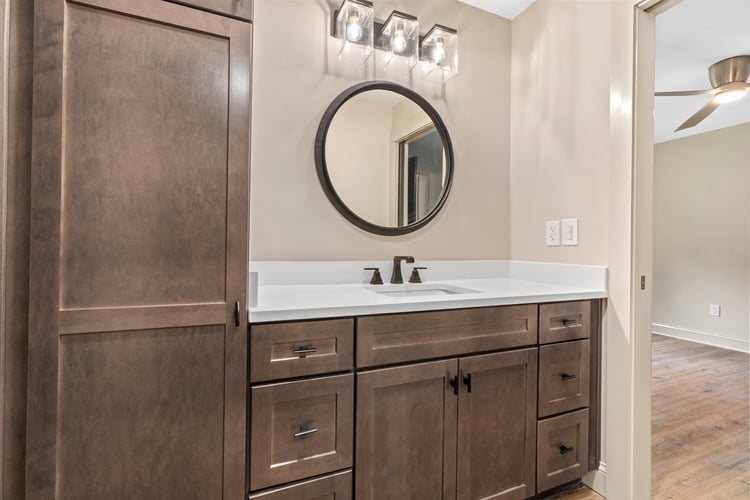 Bathroom featuring dark brown fixtures and cabinets in custom home remodel by PAXISgroup