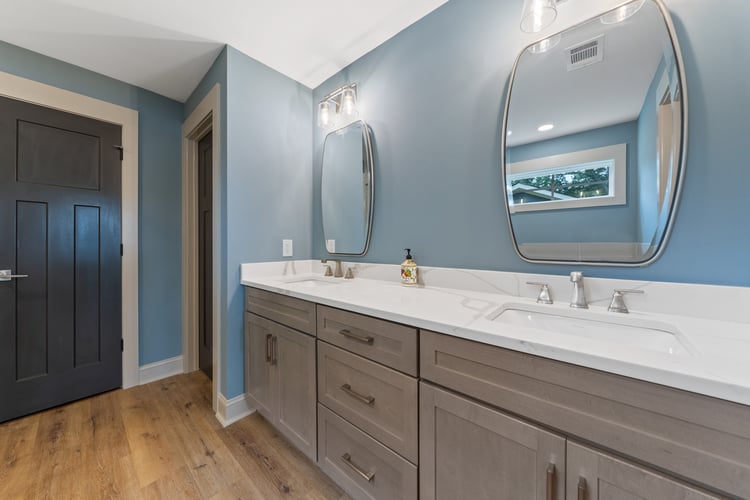 Modern bathroom with double vanity in custom home renovation by PAXISgroup