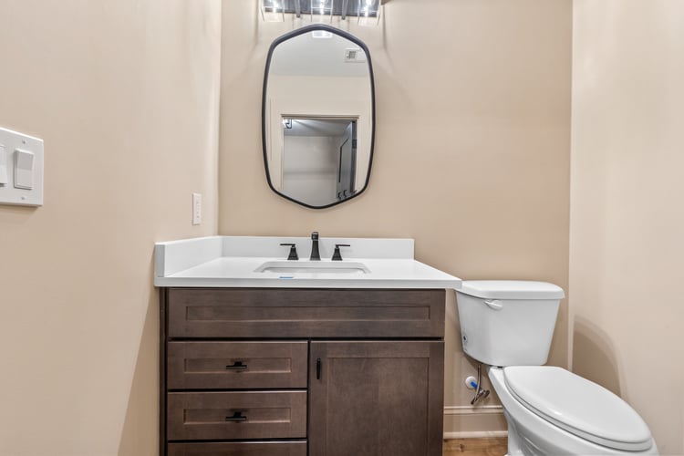 Half bath with modern design and neutral tones in custom home remodel by PAXISgroup